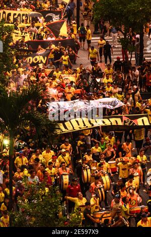 Molte persone che marciano con bandiere e strumenti musicali in 9 de Octubre Avenue, celebrando l'anniversario della squadra di calcio locale di Barcellona. Foto Stock