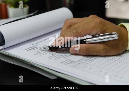 Uomini d'affari che tengono la penna sui documenti di affari Foto Stock