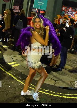 File foto datata 15/12/2020 di una donna che danzava nel West End di Londra dopo la chiusura dei pub, prima che Londra si trasferì nel più alto livello di restrizioni del coronavirus a causa di un aumento dei tassi di casi di coronavirus. Sabato 30 gennaio ricorre l'anniversario della prima morte nota del coronavirus nel Regno Unito. Data di emissione: Mercoledì 27 gennaio 2021. Foto Stock