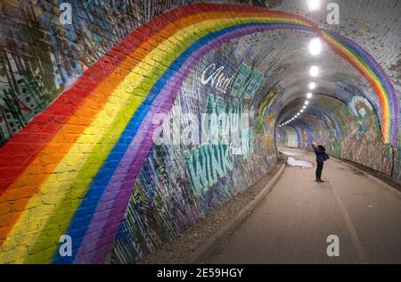 File photo datato 21/04/2020 una donna che fotografa un murale arcobaleno nel Colinton Tunnel, Edimburgo, mentre il Regno Unito continuò a bloccarsi per contribuire a frenare la diffusione del coronavirus. Sabato 30 gennaio ricorre l'anniversario della prima morte nota del coronavirus nel Regno Unito. Data di emissione: Mercoledì 27 gennaio 2021. Foto Stock