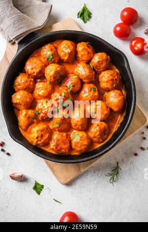 Polpette fatte in casa in salsa di pomodoro primo piano. Polpette di manzo in teglia di ghisa su sfondo bianco. Foto Stock