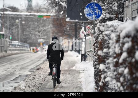 Monaco, Germania. 26 gennaio 2021. Foto a tema inverno nella pandemia del coronavirus. L'inizio dell'inverno a Monaco di Baviera il 26 gennaio 2021 il ciclista si muove su un percorso ciclistico sgomberato. | utilizzo in tutto il mondo credito: dpa/Alamy Live News Foto Stock