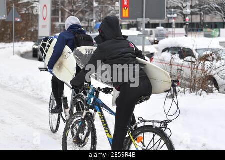 Le loro biciclette. 26 gennaio 2021. Foto a tema inverno nella pandemia del coronavirus. Dopo l'inizio dell'inverno, i surfisti gironzono intorno all'Eisbach a Monaco il 26 gennaio 2021. I surfisti trasportano le loro tavole da surf sulle loro biciclette. | utilizzo in tutto il mondo credito: dpa/Alamy Live News Foto Stock