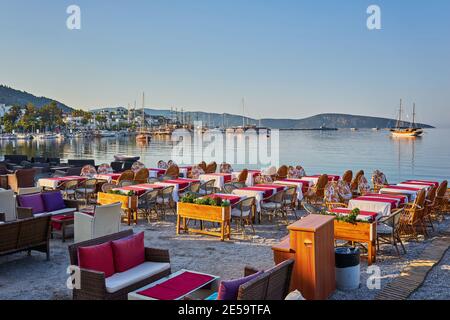 Carino tavolo e sedie e ombrellone in spiaggia al ristorante sul mare a bodrum, Turchia Foto Stock