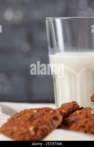 Biscotti croccanti al cioccolato con un bicchiere di latte da vicino Foto Stock