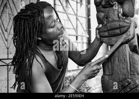 JOHANNESBURG, SUD AFRICA - 05 Gen 2021: Johannesburg, Sud Africa - 17 Gennaio 2011: African Man scultore che scultura una statua tradizionale fuori dal woo Foto Stock