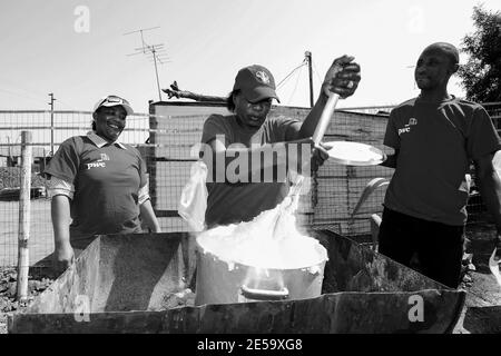 JOHANNESBURG, SUDAFRICA - 05 gennaio 2021: Soweto, Sudafrica - 10 settembre 2011: Donna africana che cucina Mielie Pap porridge di mais sulla strada laterale i Foto Stock