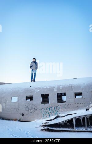 Uomo in piedi su un relitto aereo a Solheimasandur, Islanda Foto Stock