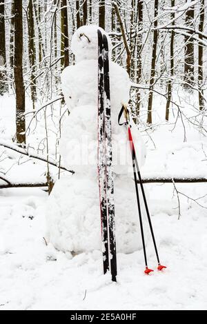 pupazzo di neve fatto a mano con sci nel parco cittadino innevato giorno invernale Foto Stock
