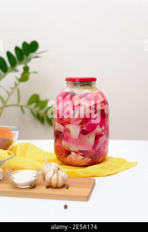 Fermentativo di cavolo rosa sottaceto con barbabietole e carote in salamoia in un vaso su uno sfondo chiaro Foto Stock