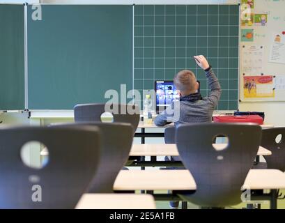 21 gennaio 2021, Brandeburgo, Oranienburg: Joel, di nove anni, del terzo grado, si siede in una classe alla Comenius School durante una lezione scolastica sul laptop in piedi di fronte ad una lavagna sul tavolo. Cinque anni fa, la scuola elementare integrativa con gruppi di sostegno linguistico si è trasferita in un nuovo edificio a Oranienburg-Süd. Foto: Soeren Stache/dpa-Zentralbild/ZB Foto Stock
