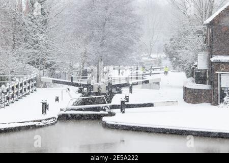 La scena innevata lungo il canale di Coventry vicino ad Atherstone, nel North Warwickshire. Nella foto sono raffigurate le serrature nel centro della città di Atherstone. Foto Stock