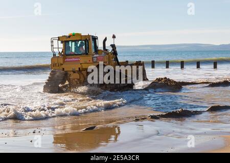 Cat D6T LGP bulldozer crawler caterpillar - programma di rinnovo dei groyne in legno che si svolge sulla spiaggia ad Alum Chine, Bournemouth, Dorset UK a gennaio Foto Stock