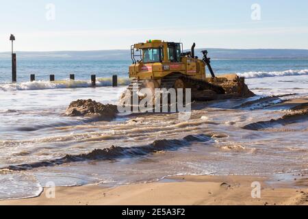 Cat D6T LGP bulldozer crawler caterpillar - programma di rinnovo dei groyne in legno che si svolge sulla spiaggia ad Alum Chine, Bournemouth, Dorset UK a gennaio Foto Stock