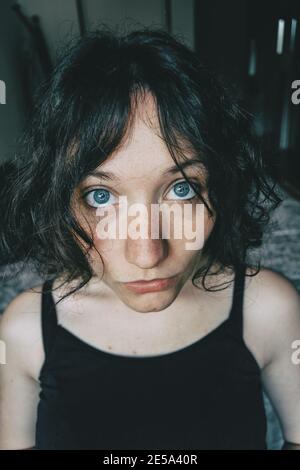 Ritratto di una bella ragazza con grandi occhi blu guardando alla macchina fotografica con l'espressione sorpresa Foto Stock