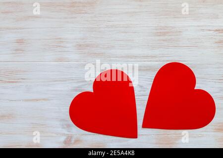 Coppia cuori di carta rossi isolati su sfondo bianco vintage verniciato. Spazio di copia. Mockup per San Valentino. Disposizione piatta. Foto Stock