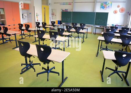 Oranienburg, Germania. 21 Gennaio 2021. Le sedie sono collocate sulle panchine della scuola in un'aula vuota della scuola Comenius. Cinque anni fa la scuola elementare integrativa con gruppi di sostegno linguistico si era trasferita a Oranienburg-Süd in un nuovo edificio. Credit: Soeren Stache/dpa-Zentralbild/ZB/dpa/Alamy Live News Foto Stock