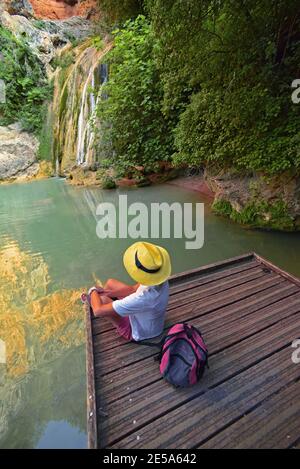 Wanderer seduto sul ponte di legno alla cascata Vallon des Carmes, Francia, Dept Var, Barjols Foto Stock