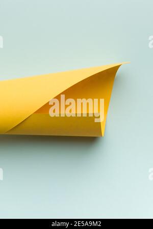 Il foglio di carta giallo brillante su uno sfondo blu chiaro. Foto Stock