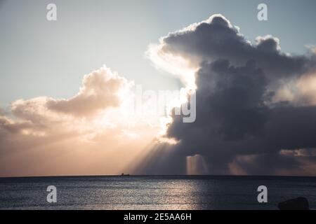 Grande nuvola di Cumulonimbus e raggi di sole all'orizzonte sopra Nave di trasporto al largo della costa di Penzance Foto Stock