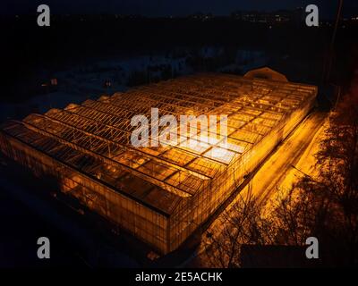 Serra in vetro moderno e luminoso nella notte d'inverno, vista aerea. Foto Stock