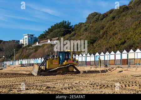 Cat D6T LGP bulldozer crawler caterpillar - programma di rinnovo dei groyne in legno che si svolge sulla spiaggia ad Alum Chine, Bournemouth, Dorset UK a gennaio Foto Stock