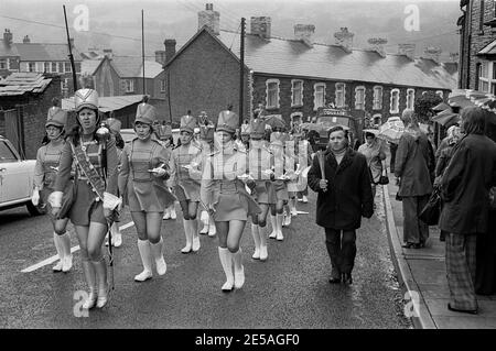 Una band jazz che marciava per le strade di Cwmfelinfach in un giorno di carnevale bagnato, Galles del Sud, 1976 Foto Stock