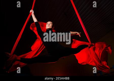 Ragazza aeralista facendo spago su tele aeree. Acrobazie nell'aria Foto Stock