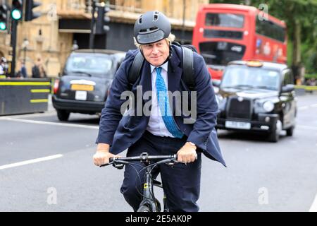Boris Johnson MP, politico del Partito conservatore britannico, in bicicletta al Parlamento di Westminster, Londra, Regno Unito Foto Stock