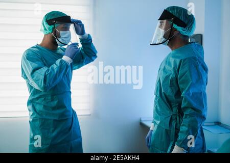 Chirurghi che si preparano per l'intervento chirurgico durante l'epidemia di coronavirus - Focus sulla testa destra del medico Foto Stock