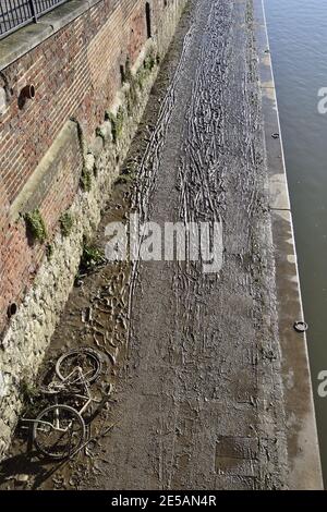 Maidstone, Kent, Regno Unito. Impronte, tracce di pneumatici e una vecchia bicicletta in fango spesso lasciata su un sentiero basso lungo il fiume dopo l'alluvione del fiume Medway, Foto Stock