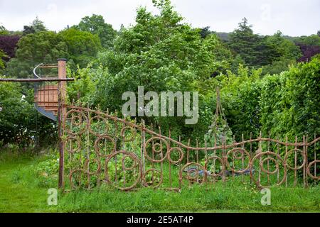 Hazel e salice copertura decorativa in modello di cerchi con prato di fiori selvatici oltre, e scala a chiocciola nel Belmond Enchanted Gardens - RHS C Foto Stock