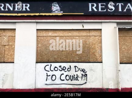 Swansea, Regno Unito. 27 gennaio 2021. Graffiti sul lato chiuso e imbarcato su Cape Horner pub nel quartiere St Thomas di Swansea dicendo "chiuso a causa di Covid 19" Credit: Phil Rees/Alamy Live News Foto Stock