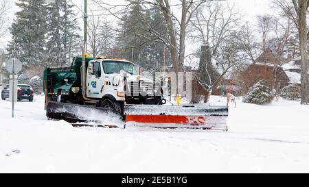 Spazzaneve camion in movimento che disciuta una strada comunale, strada, dopo la nevicata pesante, Cambridge, Ontario, Canada Foto Stock