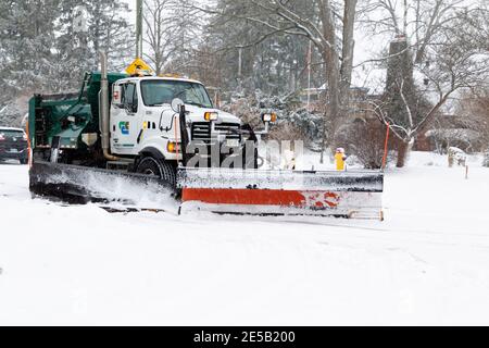 Spazzaneve camion in movimento che disciuta una strada comunale, strada, dopo la nevicata pesante, Cambridge, Ontario, Canada Foto Stock