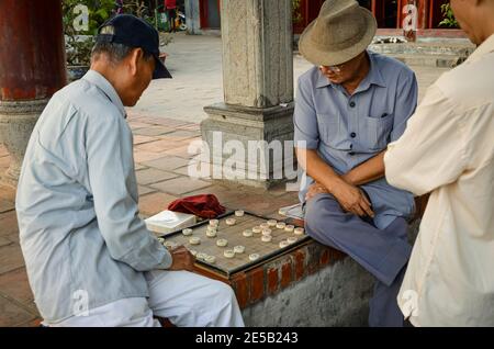 Uomini che giocano gioco da tavolo nel tempio di Ngoc Son, Hanoi, Vietnam Foto Stock