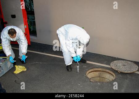 Marsiglia, Francia. 26 gennaio 2021. Gli operatori sanitari che indossano tute di protezione individuale (PPE) prelevano un campione di acque reflue dall'uscita fognaria di una casa di riposo a Marsiglia. L'unità COMETE (Covid Marseille Environmental Testing Expertise) raccoglie campioni di acque reflue in vari punti della città per determinare i quartieri, le scuole o alcuni edifici contaminati da Covid-19 attraverso il test di questi campioni. Credit: SOPA Images Limited/Alamy Live News Foto Stock