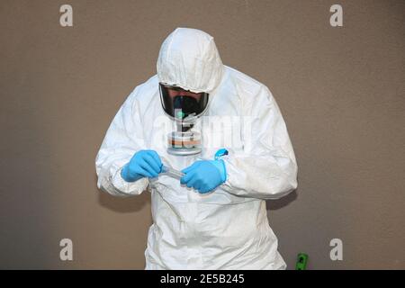 Marsiglia, Francia. 26 gennaio 2021. Un operatore sanitario che indossa tute di protezione individuale (PPE) preleva un campione di acque reflue dall'uscita fognaria di una casa di riposo a Marsiglia. L'unità COMETE (Covid Marseille Environmental Testing Expertise) raccoglie campioni di acque reflue in vari punti della città per determinare i quartieri, le scuole o alcuni edifici contaminati da Covid-19 attraverso il test di questi campioni. Credit: SOPA Images Limited/Alamy Live News Foto Stock