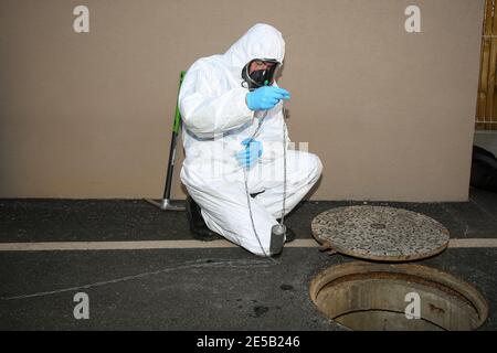 Marsiglia, Francia. 26 gennaio 2021. Un operatore sanitario che indossa una tuta per dispositivi di protezione individuale (DPI) preleva un campione durante il test delle acque reflue. L'unità COMETE (Covid Marseille Environmental Testing Expertise) raccoglie campioni di acque reflue in vari punti della città per determinare i quartieri, le scuole o alcuni edifici contaminati da Covid-19 attraverso il test di questi campioni. Credit: SOPA Images Limited/Alamy Live News Foto Stock