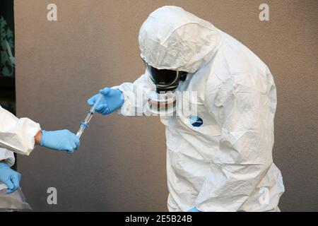 Marsiglia, Francia. 26 gennaio 2021. Gli operatori sanitari che indossano tute di protezione individuale (DPI) prelevano un campione dall'uscita fognaria di una casa di riposo durante l'analisi delle acque reflue. L'unità COMETE (Covid Marseille Environmental Testing Expertise) raccoglie campioni di acque reflue in vari punti della città per determinare i quartieri, le scuole o alcuni edifici contaminati da Covid-19 attraverso il test di questi campioni. Credit: SOPA Images Limited/Alamy Live News Foto Stock