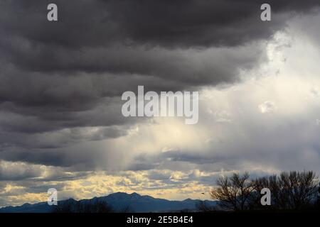 Nuvole oscure e minacciose di cumuli si formano nel cielo in una fredda giornata invernale nel sud-ovest americano vicino a Santa Fe, New Mexico USA. Foto Stock