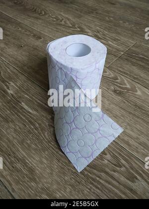 Il rotolo della carta igienica poggia su parquet di legno. Le attrezzature individuali per l'igiene. Digitare a mano Foto Stock
