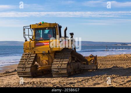 Cat D6T LGP bulldozer crawler caterpillar - programma di rinnovo dei groyne in legno che si svolge sulla spiaggia ad Alum Chine, Bournemouth, Dorset UK a gennaio Foto Stock