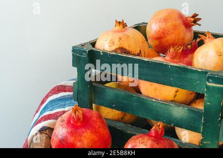 Melograni freschi in una vecchia scatola su sfondo di legno Foto Stock