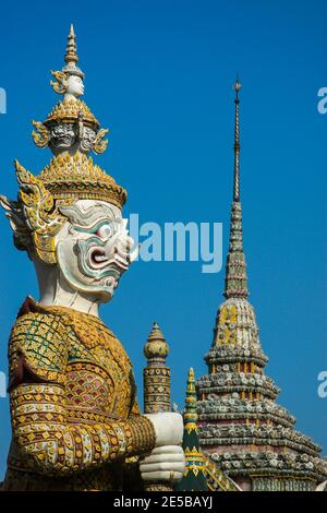 Una statua e una guglia custode all'interno dell'imponente Grande Palazzo Imperiale di Bangkok, uno dei luoghi più suggestivi della città. Foto Stock