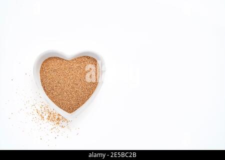 Fibra di carciofo di Gerusalemme in ciotola a forma di cuore isolato su sfondo bianco, vista dall'alto Foto Stock