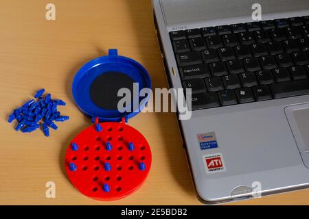 Gioco Solitario in plastica blu e rossa brillante dall'alto non c'è modo di vincere con un angolo di notebook visibile Foto Stock