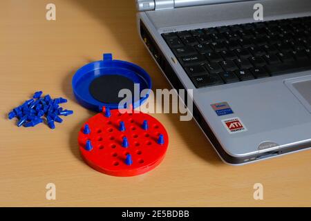 Gioco Solitario in plastica blu e rossa brillante dall'alto non c'è modo di vincere con un angolo di notebook visibile Foto Stock