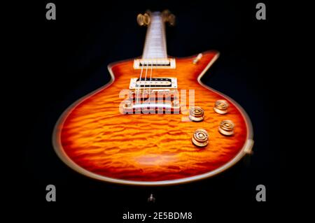 Basso angolo stilizzato di chitarra elettrica vintage isolata con sunburst terminare su uno sfondo nero Foto Stock