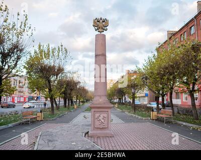 Un pilastro con lo stemma dello zarista Impero Russo in cima e lo stemma moderno di armi della città in fondo al parco Moskovsky tr Foto Stock